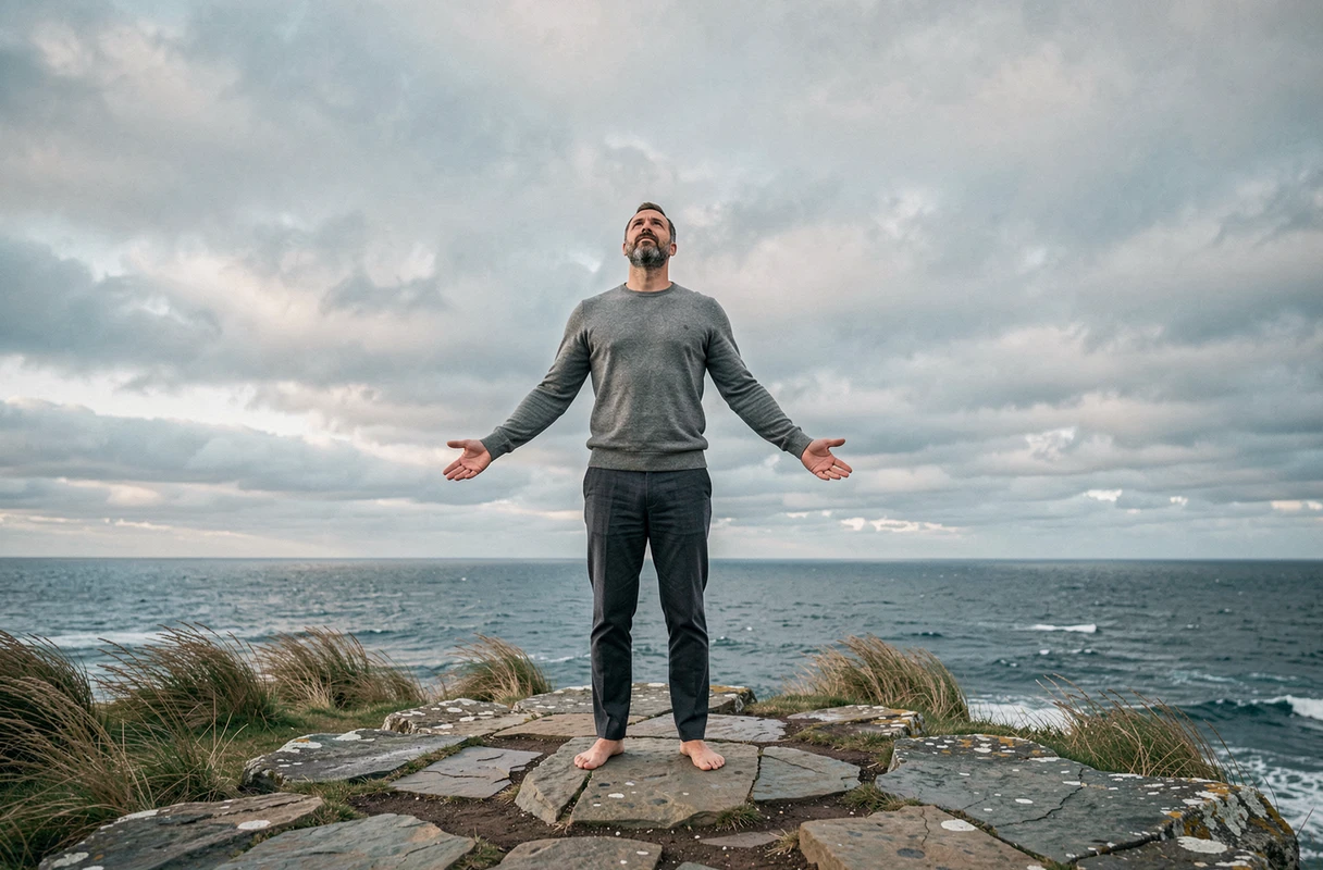 Homme face à l'immensité de l'océan sur une falaise rocheuse, symbole de l'éveil spirituel et de l'élévation vers la 5D