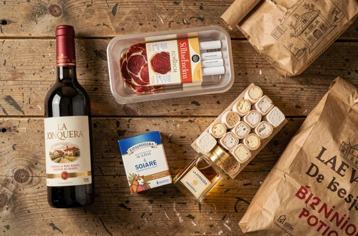 Sélection de produits typiques achetés à La Jonquera : jambon ibérique, vin espagnol, parfum et nougat disposés sur une table en bois